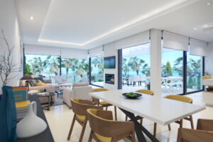 3D rendering and interior design of a chic white main living area with a sea view.
